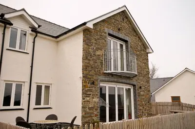 a brick house with a balcony and a table at Brynhyfryd in Aberystwyth