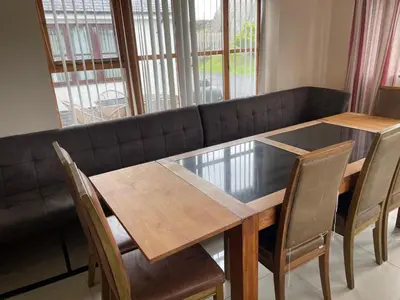 a dining room table and chairs with a black couch at Brynhyfryd in Aberystwyth