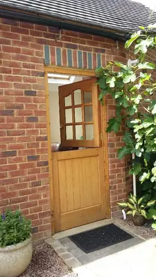 a brick building with a wooden door with a window at The Snicketts in Ludlow