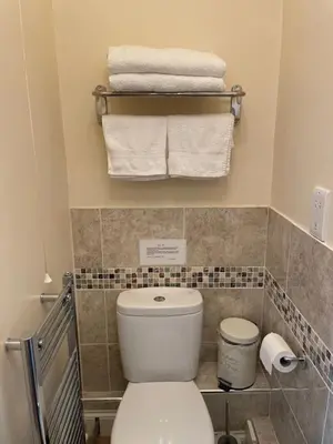 a bathroom with a white toilet and towels at The Snicketts in Ludlow