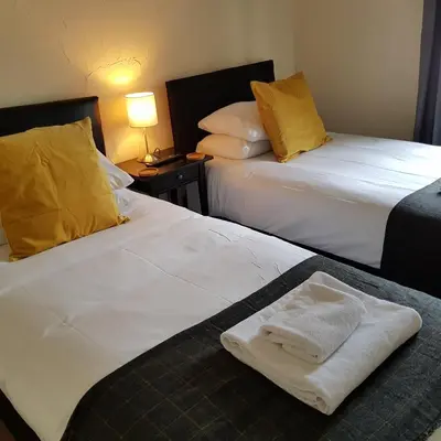 two beds sitting next to each other in a room at Crown Inn in Rhayader