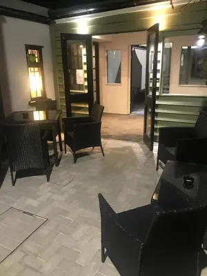 a lobby with chairs and tables and a room with doors at Crown Inn in Rhayader