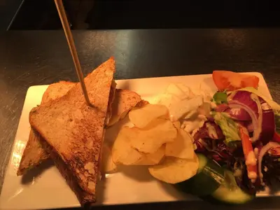 a plate of food with a sandwich and a salad at Crown Inn in Rhayader