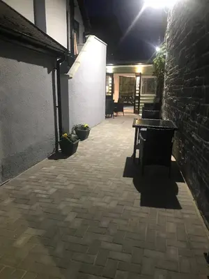 a patio at night with a table and a brick wall at Crown Inn in Rhayader