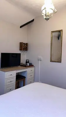 a bedroom with a bed and a desk and a mirror at Greylands Guest House in Llandrindod Wells