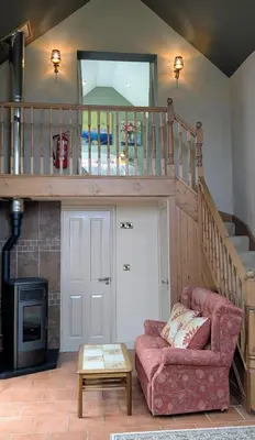 a living room with a couch and a staircase at The Old Vicarage Dolfor in Newtown