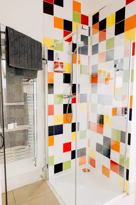 a bathroom with a colorful tile wall at The Stable at Ty Beic in Bala