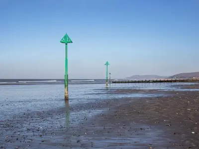 two poles in the sand on a beach at Morolwg in Borth