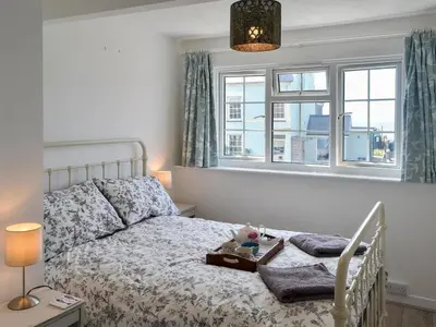 a bedroom with a bed and two windows at Morolwg in Borth