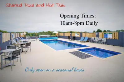 a swimming pool with tables and chairs next to at The Hay Suite in Aberystwyth