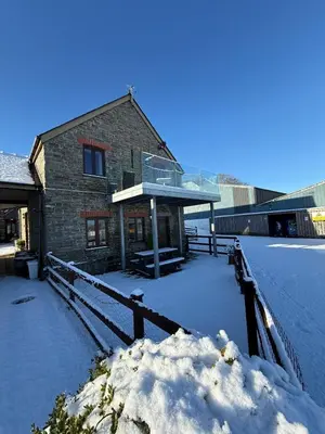 a building with snow on the ground in front of it at The Hay Suite in Aberystwyth