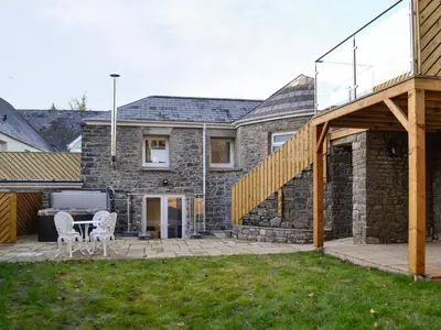 a patio with a table and chairs in front of a house at Cornel Clyd Cosy Corner in Cilcennin
