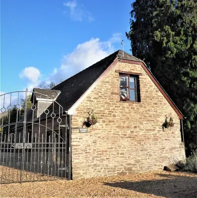 a brick building with a window and a fence at Penybont Barn in Llangorse