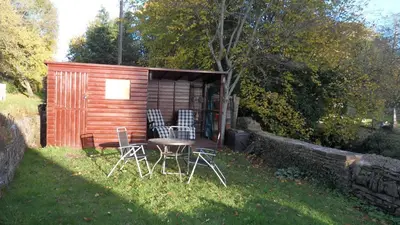 a small cabin with chairs and a table in the grass at Penybont Barn in Llangorse