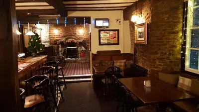 a restaurant with tables and chairs and a fireplace at The Wheatsheaf Inn in Ludlow