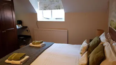 a bedroom with a bed with two towels on it at The Wheatsheaf Inn in Ludlow