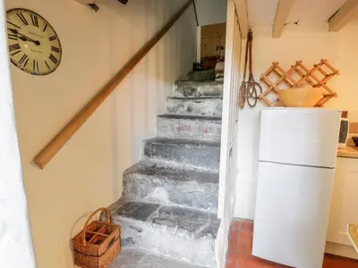 a staircase with a refrigerator and a clock on the wall at Plas Arenig in Blaenau-Ffestiniog