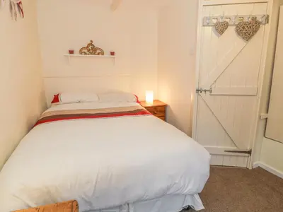 a bedroom with a white bed and a door at Plas Arenig in Blaenau-Ffestiniog