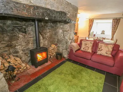 a living room with a red couch and a fireplace at Plas Arenig in Blaenau-Ffestiniog