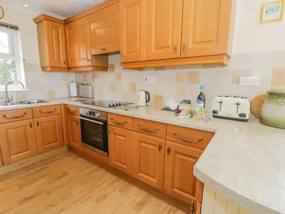 a kitchen with wooden cabinets and a counter top at Bryn Coch Bach in Dyffryn