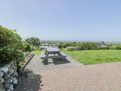 a picnic table sitting on top of a brick patio at Bryn Coch Bach in Dyffryn