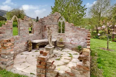 a brick wall with a bench in a yard at The Folly in Hereford