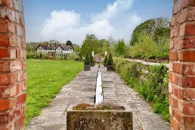 a stone path through a garden with houses in the background at The Folly in Hereford