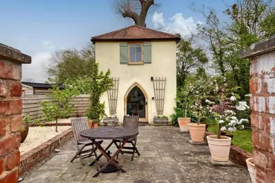 a patio with a table and chairs in front of a building at The Folly in Hereford
