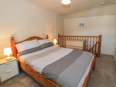 a bedroom with a wooden bed with two night stands and two lamps at Ty Uchaf in Dyffryn