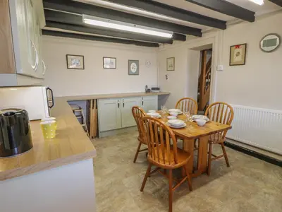 a kitchen with a table and chairs in a kitchen at Ty Uchaf in Dyffryn