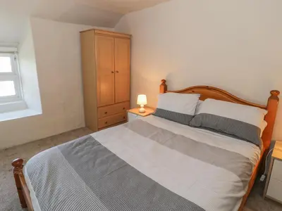 a bedroom with a large bed and a dresser at Ty Uchaf in Dyffryn