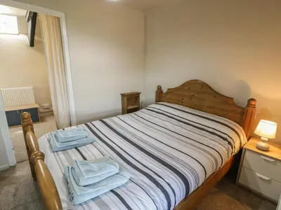 a bedroom with a bed with two towels on it at Ty Uchaf in Dyffryn
