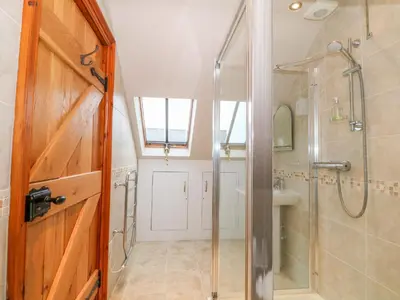 a bathroom with a shower and a glass shower stall at Craig Y Deryn in Tywyn