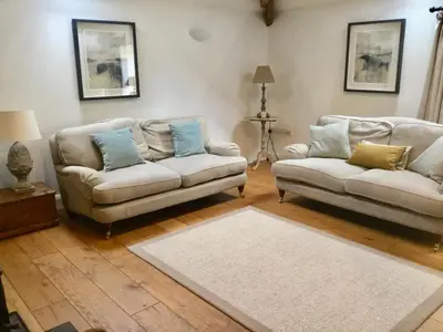 a living room with two couches and a rug at Cuckoo Barn at Penygaer farm near the Brecon Beacons in Llandovery