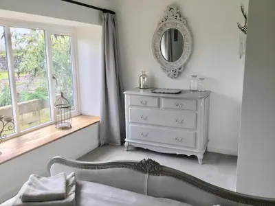 a bedroom with a white dresser and a mirror at Cuckoo Barn at Penygaer farm near the Brecon Beacons in Llandovery
