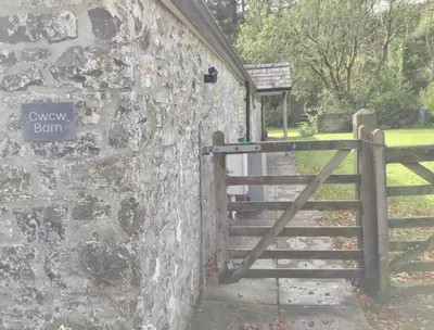 an entrance to a stone wall with a gate at Cuckoo Barn at Penygaer farm near the Brecon Beacons in Llandovery