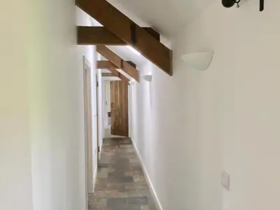 a hallway in a house with white walls and wooden beams at Cuckoo Barn at Penygaer farm near the Brecon Beacons in Llandovery