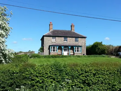 an old brick house on a green field at Upper Letton Farm in Leintwardine