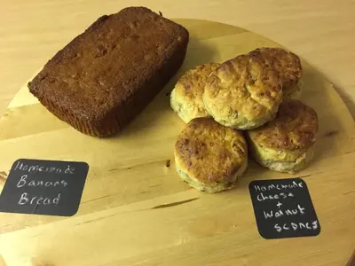 three biscuits and a loaf of bread on a wooden cutting board at Oceandrive in Barmouth