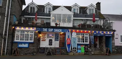 a building with a surf shop on the street at The Sup Shack Wellington Inn in New Quay