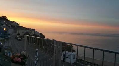 a view of the ocean at sunset from a balcony at The Sup Shack Wellington Inn in New Quay