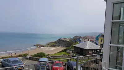 a view of the beach from the balcony of a house at The Sup Shack Wellington Inn in New Quay