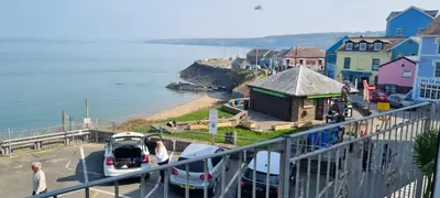 a group of people walking on a pier near a beach at The Sup Shack Wellington Inn in New Quay