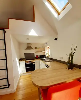 a kitchen with a wooden table in a room at Little Smithy in Shrewsbury