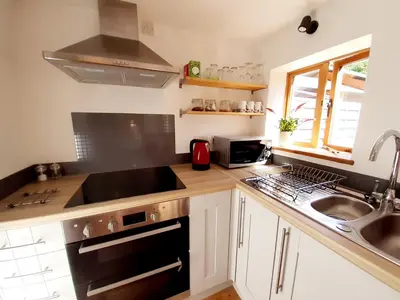 a kitchen with a sink and a stove top oven at Little Smithy in Shrewsbury