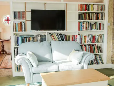 a living room with a couch and book shelves filled with books at Lane House in Bishops Castle