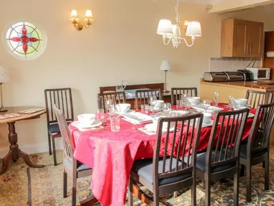 a dining room with a table with a pink table cloth at Lane House in Bishops Castle