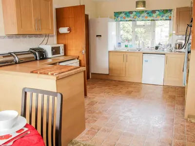 a kitchen with wooden cabinets and a white refrigerator at Lane House in Bishops Castle