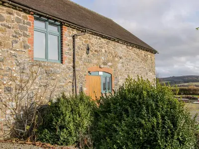 an old stone house with a orange door at Stiperstones View in Shrewsbury