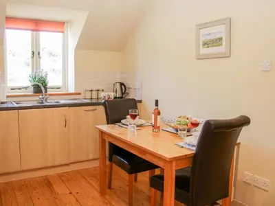 a kitchen with a wooden table with two chairs at Stiperstones View in Shrewsbury